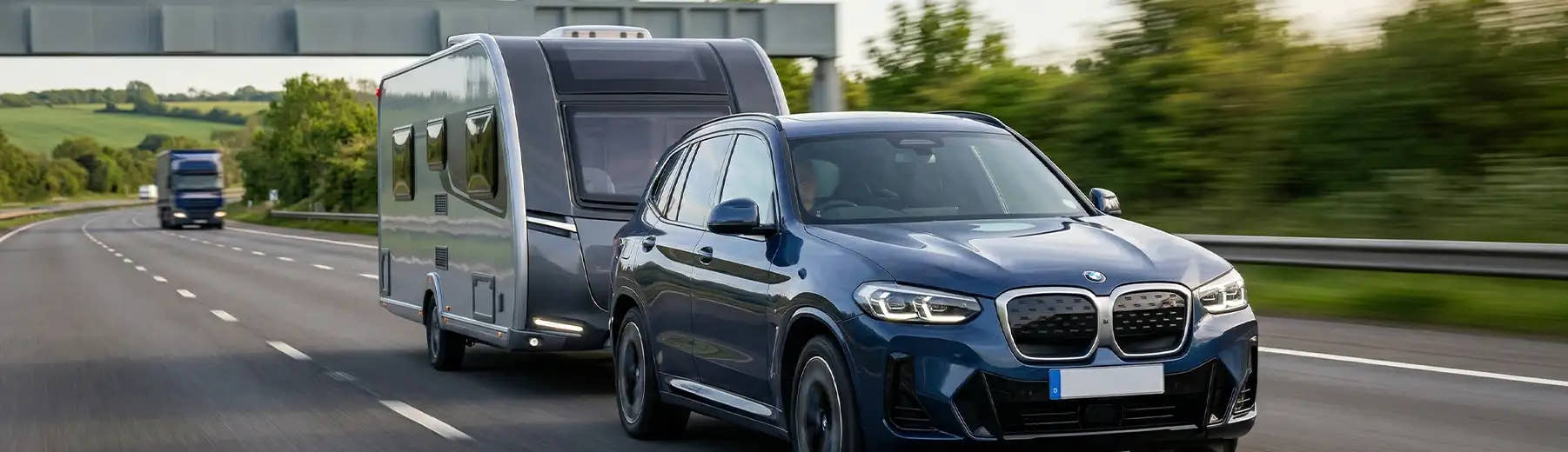 BMW car towing a caravan along a British motorway