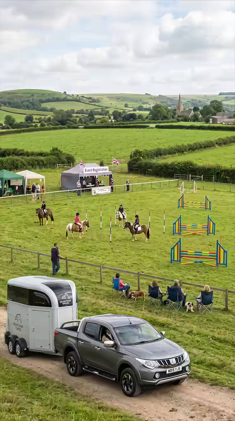 Mitsubishi pickup towing a horsebox trailer at an equestrian event
