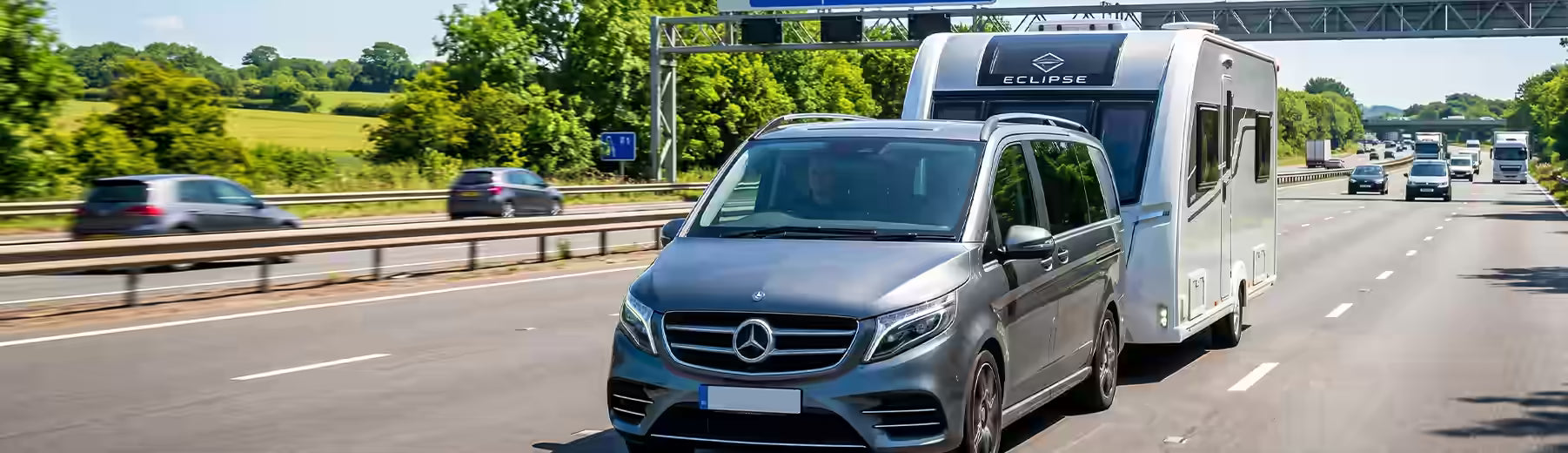 Mercedes people carrier van towing a caravan on a British motorway